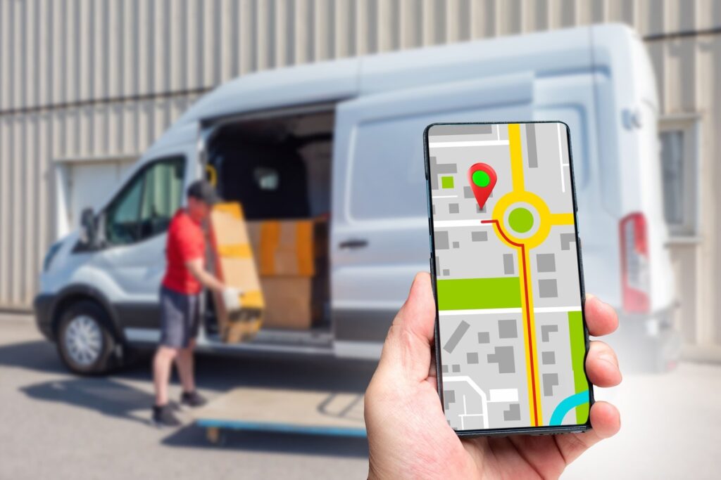 delivery van loading packages with gps courier tracking app on smartphone