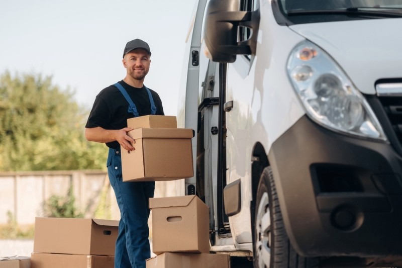 Curier livrand colet din masina de livrare